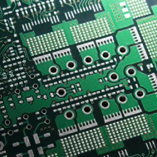 Stack of green printed circuit boards with integrated circuits, vias, copper traces, and electronic components displaying detailed PCB layout and assembly.